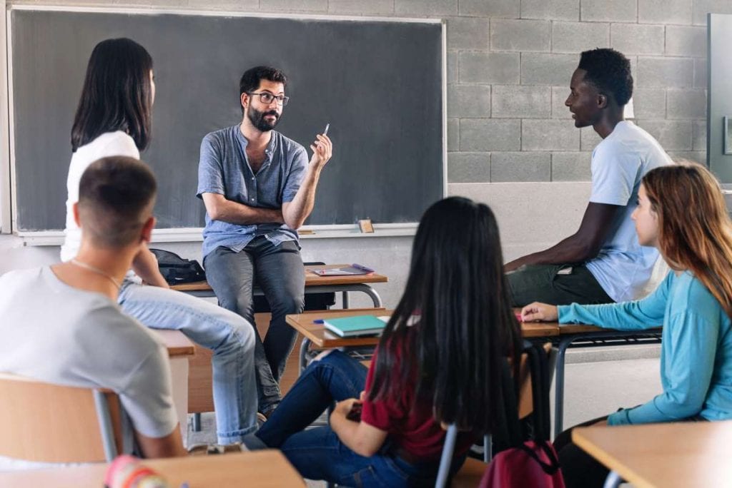 counselor with teenage students at blackboard