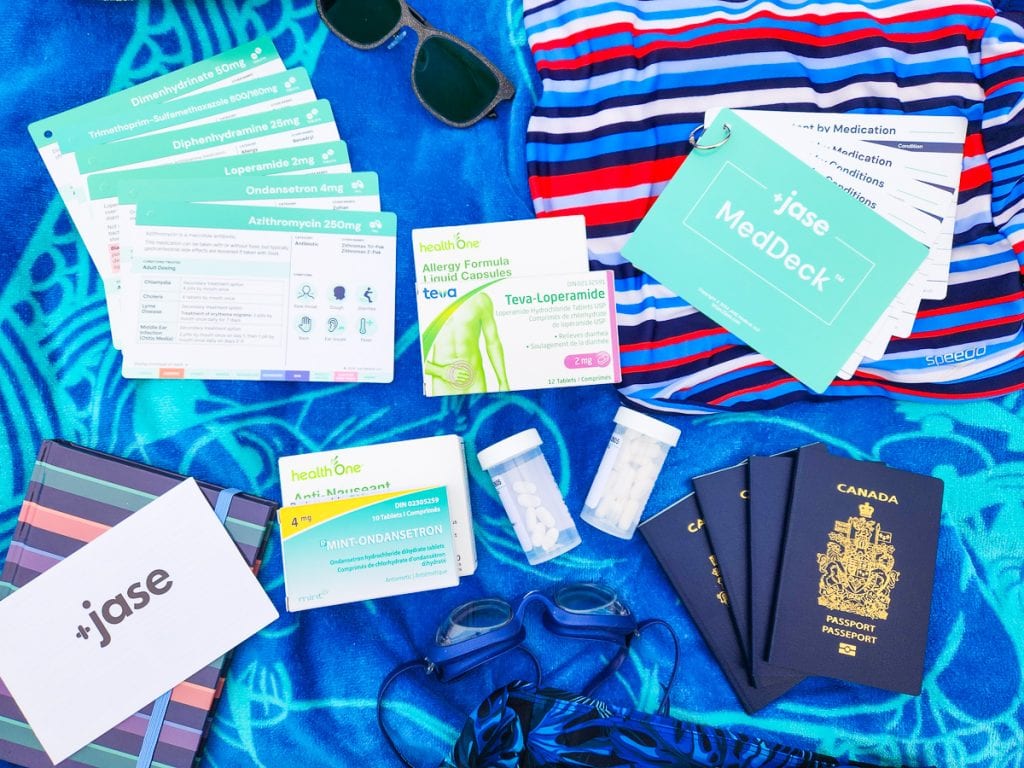 Jase Go travel kit on beach towel with travel items at the beach